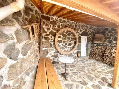 a room with a stone wall with a wooden table at Quinta Perpetua, Casa Flores in Santa Cruz da Graciosa