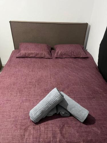 a bed with a pillow on top of it at Relatives Apartment in Mytilene