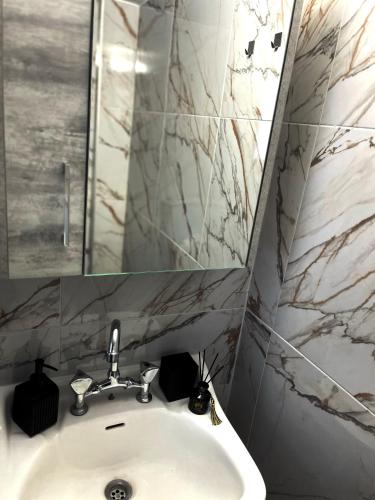a bathroom with a sink and a mirror at Relatives Apartment in Mytilene