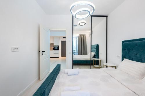 a bedroom with a large bed and a mirror at ViaPipera Apartments - Modern Stay on Pipera Blvd in Bucharest