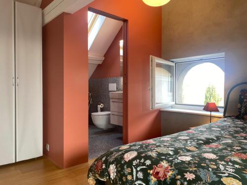 a bedroom with a bed and a bathroom with a tub at La Petite Campagne in Lonay