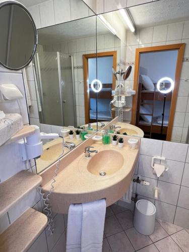 a bathroom with a sink and a large mirror at Sarah Gruber Appartements in Sankt Englmar