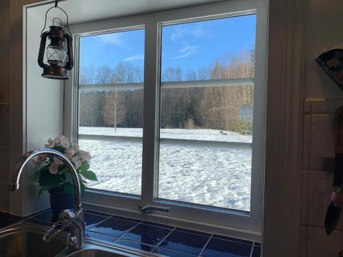 a kitchen window with a view of a snow covered yard at The Soldiers house in Ekshard