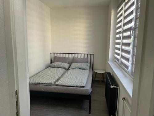 a small bed in a room with a window at Black & White Modern Apartment in Tuzla