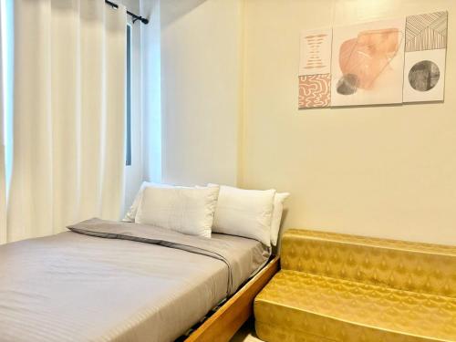 a small bedroom with a bed and a bench at Family-Friendly Condo Unit in Lapu Lapu City