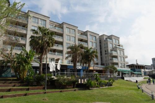 a large building with palm trees in front of it at Ideal si venis por trabajo, con cochera in Benavídez