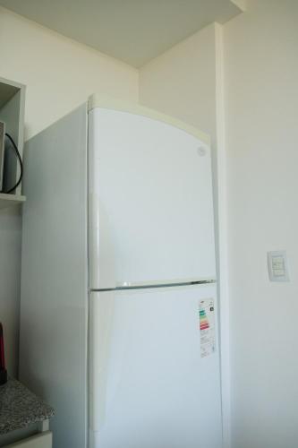 a white refrigerator in a kitchen with a white wall at Ideal si venis por trabajo, con cochera in Benavídez