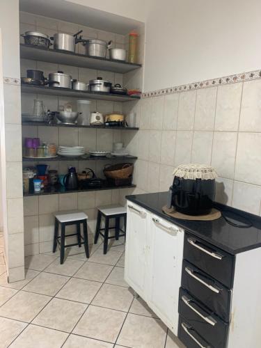 a kitchen with a counter and stools in it at Bela vista a beira mar in Marataizes
