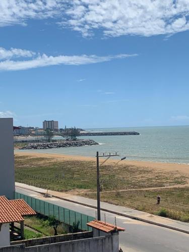 a view of the beach and the ocean from a building at Bela vista a beira mar in Marataizes