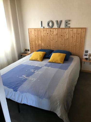 Elle comprend un grand lit avec des draps bleus et des oreillers jaunes. dans l'établissement L'Accugliente, à Lecci