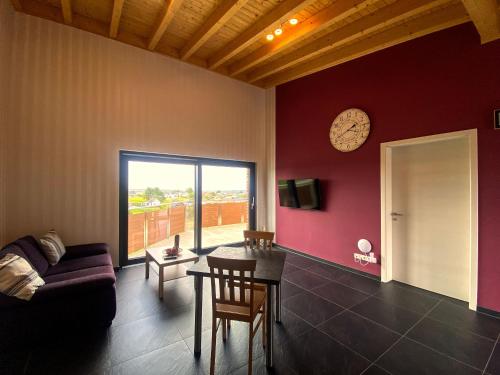 a living room with a couch and a clock on the wall at Ferienwohnung Am Weiher Wohnung 6 Für 2 Personen in Nideggen