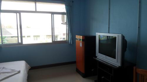 a room with a tv on a dresser and a window at Usabuy in Trang