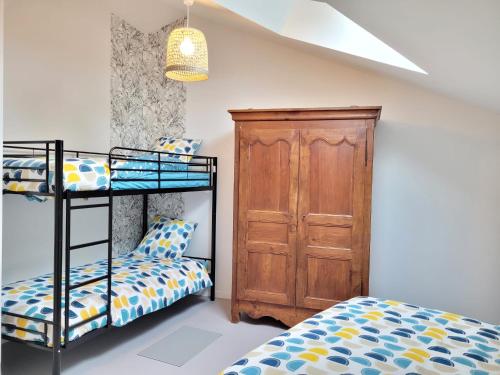 - une chambre avec 2 lits superposés et une armoire en bois dans l'établissement gite des gorges du lignon, à Grazac