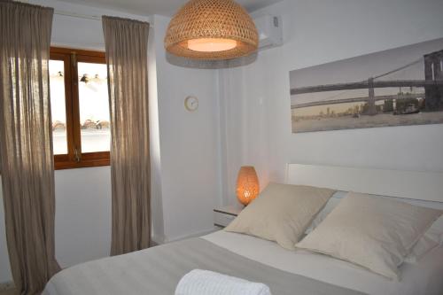 a bedroom with a bed and a lamp and a window at Zentral Gelegene Wohnung in Cómpeta