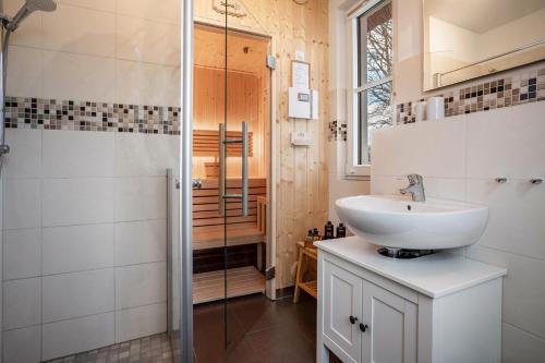 a bathroom with a sink and a shower at Ferienhaus Seeschwalbe 14 in Ummanz