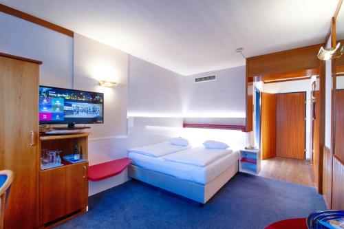a bedroom with a bed and a flat screen tv at Vienna Sporthotel in Vienna