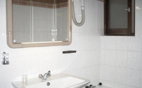 a white bathroom with a sink and a mirror at Avenir Hotel in Paris