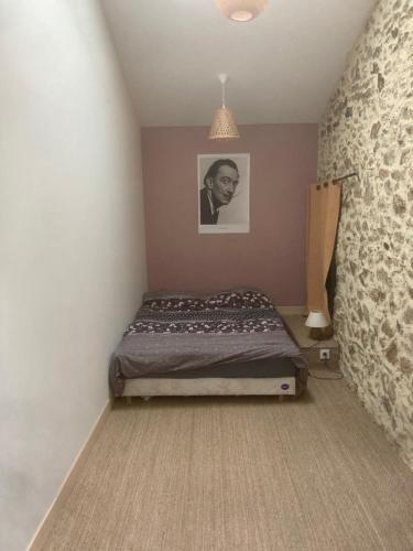 - une chambre avec un lit et une photo d'un homme dans l'établissement Premier étage d une jolie maison à la campagne, à Montravers