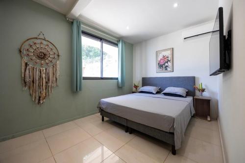 a bedroom with a bed and a window and a television at Grande villa 4 chambres avec piscine in Rémire-Camp