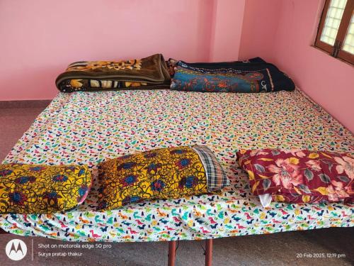 a bed with colorful sheets and pillows on it at Homestay by Anand in Naini