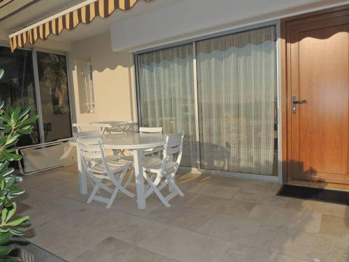 une table blanche et des chaises sur une terrasse dans l'établissement F2 3* avec Parking et Terrasse, Face à l'Étang de Thau, Proche Thermal, Tout Équipé - FR-1-571-10, à Balaruc-les-Bains