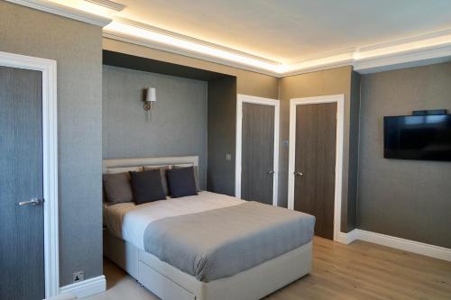 une chambre avec un lit et une télévision à écran plat dans l'établissement Chelsea Prime Location Studio, à Londres