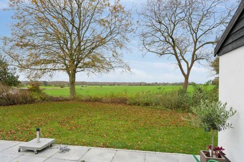 a yard with a bench and trees in a field at Stay Comfortably In Scenic Surroundings in Ellerup