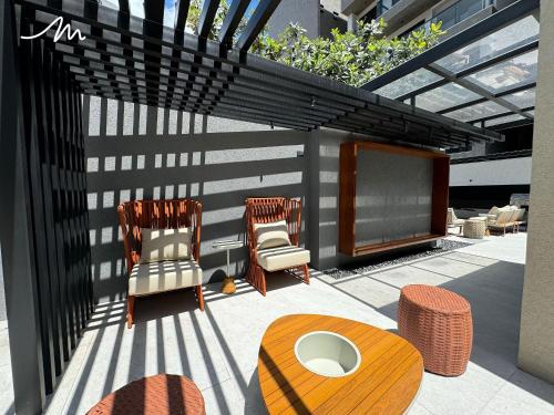 a patio with two chairs and a table at Vert House Jardim Oceania - Miramar Hospedagens in Tambaú