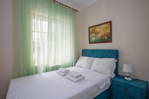 a bedroom with a bed with two towels on it at Montesan Luxury Apartments Sveti Stefan in Sveti Stefan