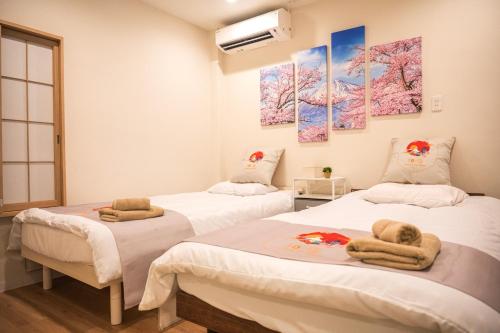 two beds in a hospital room with towels on them at 和の宿ホテルYamatoinn Akihabara#101 in Tokyo
