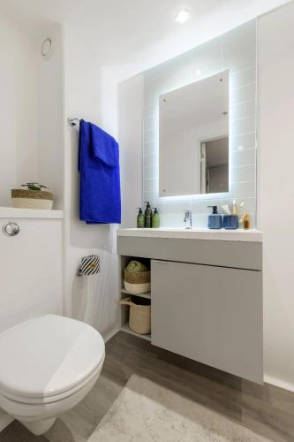 a white bathroom with a toilet and a mirror at Yugo Bottleworks in Cork
