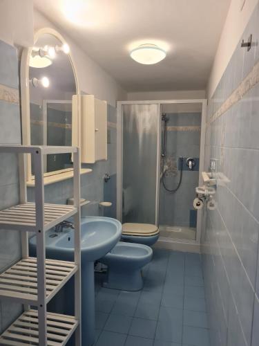 Un baño con dos inodoros, un lavabo y una ducha. en Real Venice Biennale, en Venecia