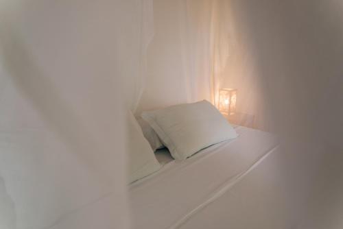 a white bed with a pillow in a room at Pousada Sossego in Pipa