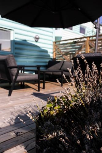 a patio with a bench and an umbrella and plants at Good Morning Lund in Lund