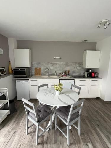 eine Küche mit Tisch und Stühlen und einer Spüle in der Unterkunft la Sainterie in Savonnières