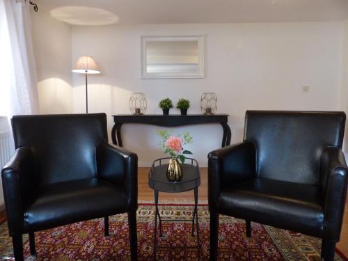 two black leather chairs in a living room with a table at Ferienhaus In Bracht Mit Garten in Rauschenberg