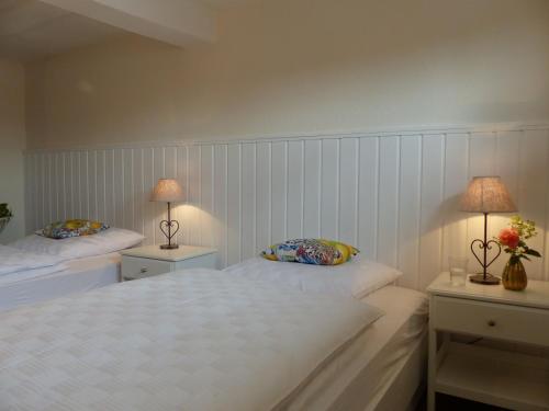 a bedroom with two beds and two lamps on tables at Ferienhaus In Bracht Mit Garten in Rauschenberg