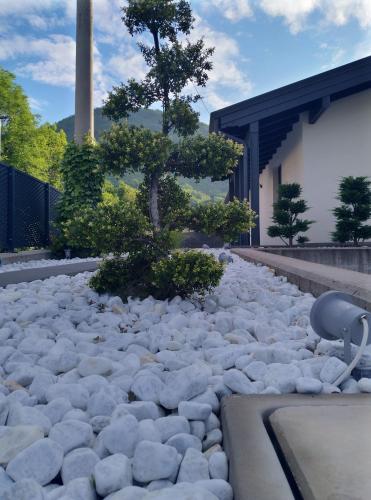 a rock garden with a tree in front of a building at Lvi Retreat in Tarcento
