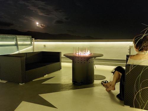 a woman is standing on a balcony with a table at Lvi Retreat in Tarcento
