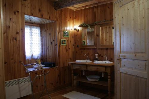 a wooden bathroom with two sinks and a window at La maison d'Anastasie in Saint-Étienne-du-Vigan