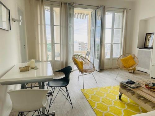 un salon avec des chaises et une table aux accents jaunes dans l'établissement Appartement Roi Albert, à Cannes