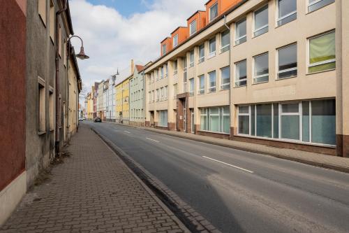 an empty street in a city with tall buildings at Ferienwohnung Markranstädt - Geräumige Apartments nahe Leipzig in Markranstädt
