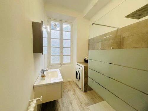 une salle de bain avec un lavabo et une fenêtre dans l'établissement Appartement Roi Albert, à Cannes