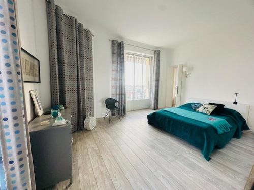 une chambre avec un lit avec une couette verte dans l'établissement Appartement Roi Albert, à Cannes