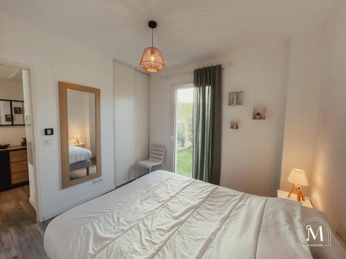 une chambre avec un grand lit et un miroir dans l'établissement Appartement cosy dans résidence avec piscine, à Sanary-sur-Mer