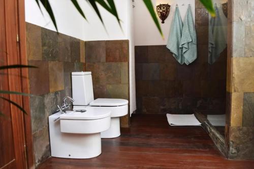 a bathroom with two toilets and a sink at Appartement Casa Hibisco Mit Schönem Garten in Uga