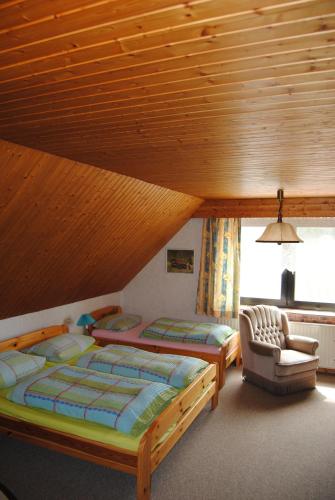 GoosefeldにあるLändliche Ferienwohnung In Beliebtem Gästehausのベッドルーム1室(ベッド2台、椅子付)