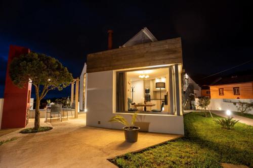 ein Haus mit einem großen Fenster auf einer Terrasse in der Nacht in der Unterkunft Ferienhaus für 2 Personen ca 43 qm in Algarvia, Azoren Sao Miguel in Algarvia