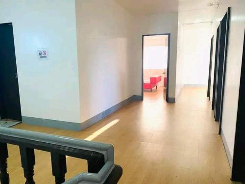 a hallway with a red chair in a room at WJV Inn San Carlos in San Carlos