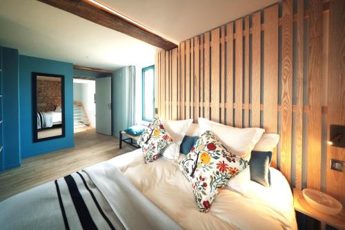 - une chambre avec des murs bleus et un lit avec des oreillers dans l'établissement Domaine à proximité de Chinon avec piscine, billard, pétanque, jeux pour enfants, à Lémeré